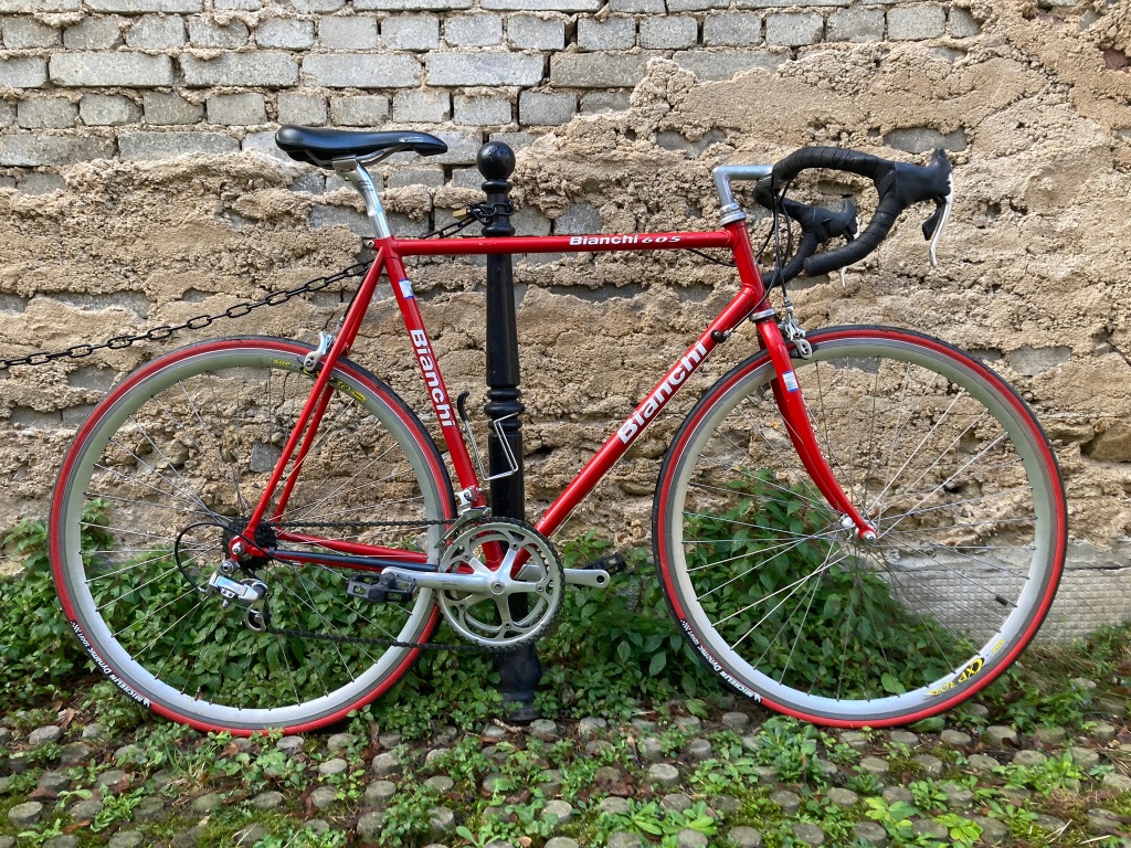 Vélo de course Bianchi de couleur rouge le long d'un mur.